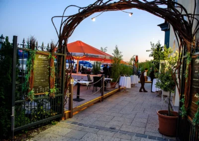 Eingang zur Hochzeitsfeier am Starnberger See mit Dekoration und großen Schirmen bei Hugos Beach Club.