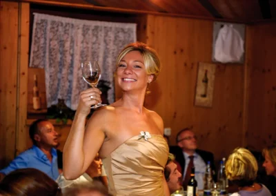 Frau hebt ein Glas bei Hochzeit im Gasthof Schmuck. Hochzeitsfotografie in Sauerlach-Arget.