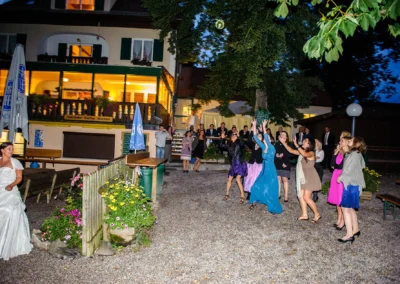 Hochzeitsreportage am Abend im Restaurant Alpenblick am Staffelsee, Brautjungfern fangen einen Blumenstrauss.