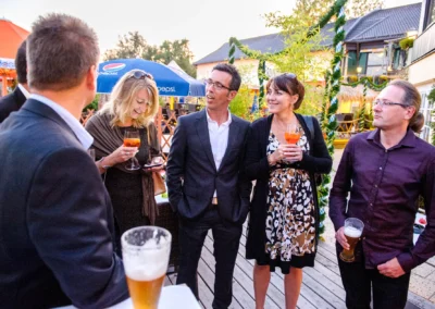 Gäste unterhalten sich bei einer Hochzeit in Hugos Beach Club, Starnberg. Hochzeitsfotograf fängt die Stimmung ein.