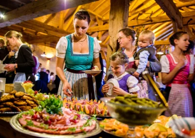 Hochzeitsbilder der Feier in Holzham zeigen Buffet mit Trachtentragenden Gaesten. Hochzeit in Bayern.
