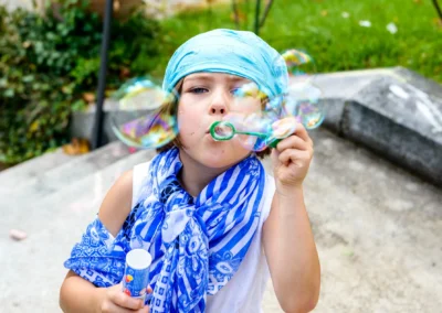 Kind spielt bei Hochzeit am Starnberger See Seifenblasen. Hochzeitsfoto zeigt Freude in Feldafing.