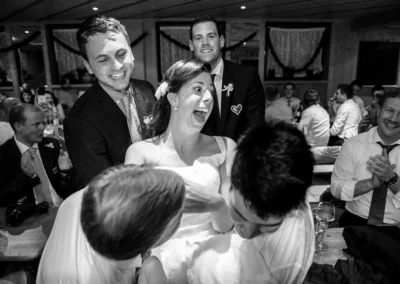 Braut wird lachend von Freunden hochgehoben bei der Hochzeit in Sauerlach-Arget, festgehalten als Hochzeitsreportage.