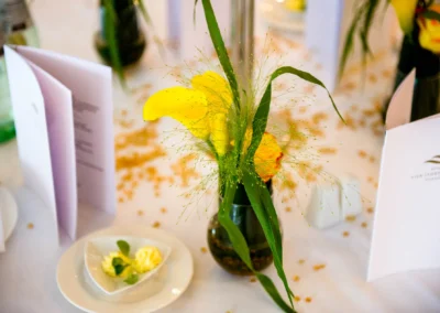 Blumengesteck auf Hochzeitstafel im Hotel Vier Jahreszeiten Starnberg, Hochzeitsfotografie Fokussierung auf Details.