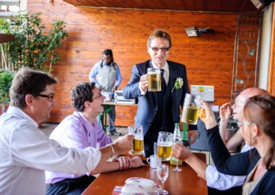 Bräutigam stößt mit Gästen bei Hochzeit im Chiemgau an, festgehalten von einem Hochzeitsfotografen.