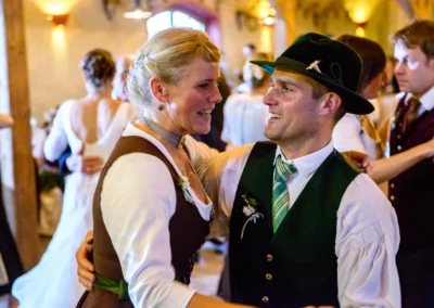 Paar tanzt auf einer Hochzeit im Hofgut zur Muehle, traditionell gekleidet. Hochzeitsreportage zeigt Freude.