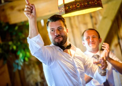 Mann mit Fliege hebt Glas bei Hochzeitsfeier im Landgasthof Stahuber Thal. Hochzeitsreportage aus Oberbayern.