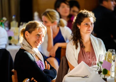 Lachende Gaeste bei einer Hochzeit in Muenchen, aufgenommen vom Hochzeitsfotografen im Seehaus, freundliche Atmosphaere.