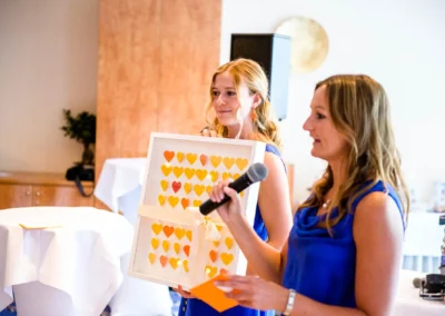 Frauen halten bei Hochzeit am Starnberger See ein gerahmtes Herzbild. Emotionale Hochzeitsfotoreportage.