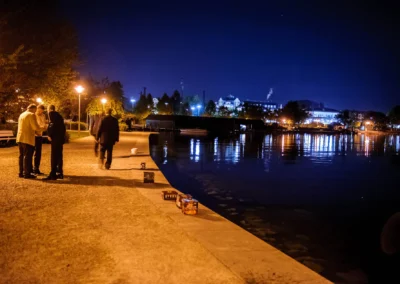 Nachtaufnahme einer Hochzeit am Starnberger See, Personen spazieren am Ufer entlang, Beleuchtung und Wasserreflexionen.