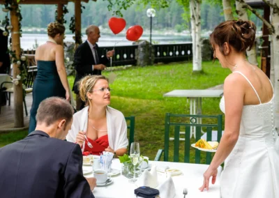 Gaste bei Hochzeit am Eibsee Hotel im Freien, Braut im Kleid, rote Luftballons, Teil der Hochzeitsreportage.