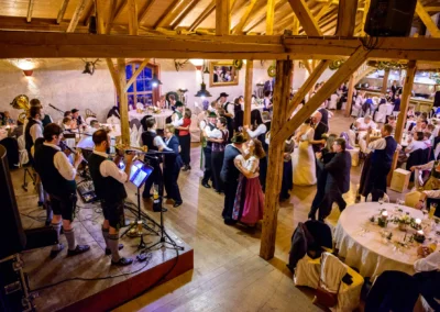 Tanzende Hochzeitsgaeste und Musikgruppe auf Hochzeit in Bruckmuehl, aufgenommen von Hochzeitsfotograf.
