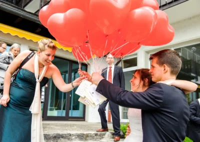 Brautpaar mit roten Herzballons bei Hochzeit nahe Garmisch, festgehalten von Hochzeitsfotograf.