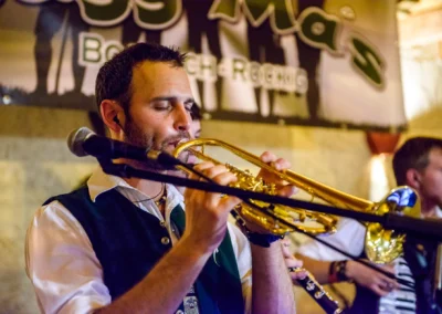 Musiker bei Hochzeit in Holzham spielt Trompete, stimmungsvolle Hochzeitsbilder für die Hochzeitsfotografie.