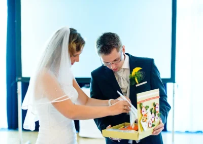 Braut und Brautigam mit Geschenk bei Hochzeit im Vier Jahreszeiten Starnberg, Hochzeitsfotografie.