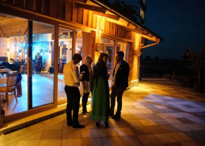 Gaste bei einer Hochzeit im Landgasthof Schmuck in Arget bei Nacht, mit Band im Hintergrund. Hochzeitsfotograf München.