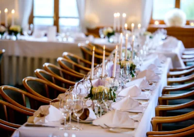 Festlich gedeckter Hochzeitstisch mit Kerzen und Blumen in Waakirchen für eine Hochzeitsreportage.