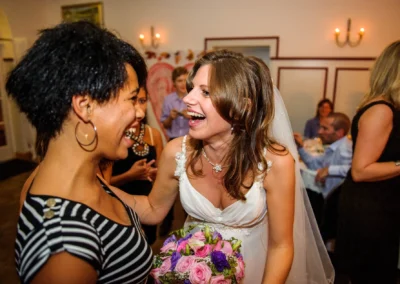 Braut lacht mit Freundinnen bei einer Hochzeit in Hugos Beach Club, festgehalten in einer Hochzeitsreportage.