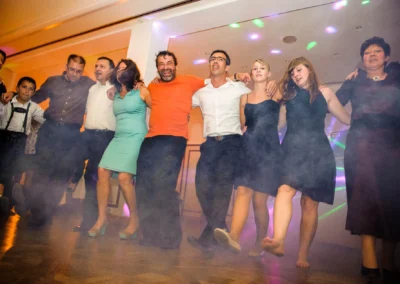 Gäste tanzen fröhlich auf einer Hochzeitsfeier bei Hugos Beach Club, Starnberger See. Hochzeitsfotografie.