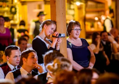 Gäste bei einer Hochzeit im Hofgut zur Mühle, eine Frau filmt die Feierlichkeiten, Hochzeitsfotografie.