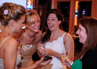 Gäste lachen bei einer Hochzeit in Sauerlach mit Sektgläsern. Hochzeitsfoto von der Feier im Gasthof und Landhotel Schmuck.