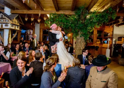 Brautpaar tanzt und feiert auf Hochzeit im Hofgut zur Muehle, umgeben von Gaesten in rustikaler Atmosphaere.