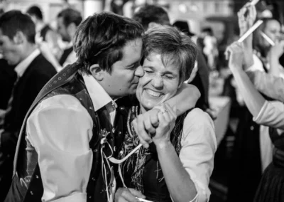Gäste lachen und umarmen sich bei einer Hochzeit in Holzham, festgehalten von einem Hochzeitsfotografen.