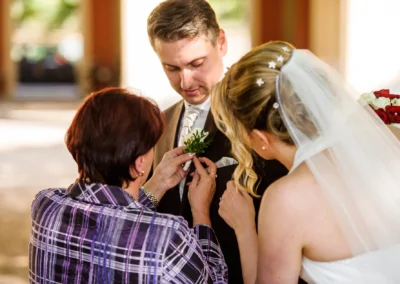 Braut und Mann im Hofgarten Muenchen, Hochzeitsfotografie mit Ansteckblume, festliche Szene.