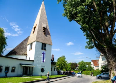 Kirche mit Turm und Personen bei einer Hochzeitsfotograf in Dachau, nördlich von München.