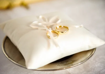 Goldene Eheringe auf weißem Kissen, aufgenommen von Hochzeitsfotograf bei Trauung in Christuskirche Gauting.