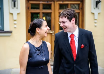 Lachendes Paar bei standesamtlicher Trauung, Schloss Ismaning. Hochzeitsfoto zeigt Freude und Eleganz.