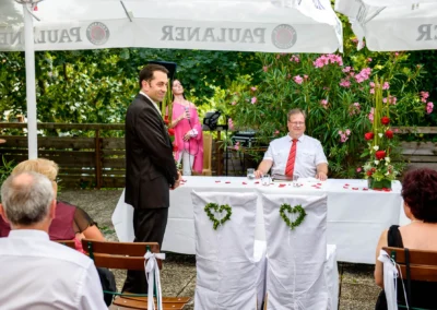 Freie Trauung im Dachauer Hinterland, Hochzeitsfotografie mit Redner und Brautigam, Sommerhochzeit im Garten.