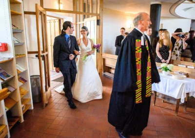 Brautpaar in Kirche nördlich von München bei der Trauung, begleitet von einem Geistlichen. Hochzeitsfotografie.