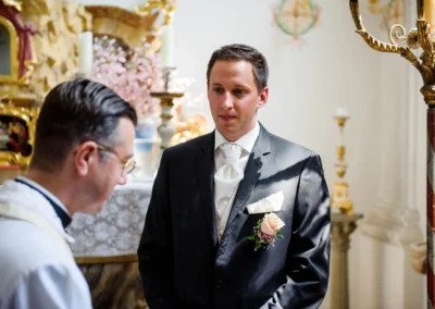 Bräutigam im Anzug bei kirchlicher Trauung in Schloss Aufhausen, Hochzeitsfoto nahe München in Oberbayern.