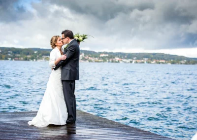 Brautpaar auf Steg am Starnberger See bei einer Hochzeit, himmlische Hochzeitsfotografie am Wasser.