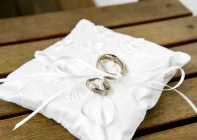 Zwei Eheringe auf einem bestickten Kissen bei einer Hochzeitsreportage in Trausnitz.