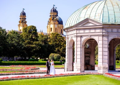 Brautpaar posiert im Hofgarten Muenchen, umgeben von Blumen und Pavillon, Hochzeitsfotografie in der Altstadt.