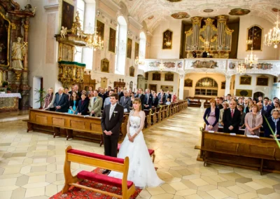 Brautpaar beim Ja-Wort in der Heilig-Geist-Kirche Neuburg, umgeben von Familien und Freunden. Hochzeitsreportage.