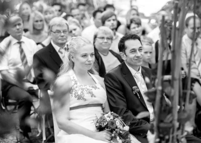 Brautpaar bei freier Trauung, umgeben von Gaesten, gehalten im Dachauer Hinterland. Hochzeitsfotograf-Roehrmoos.