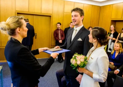 Brautpaar mit Standesbeamtin bei der Trauung im Standesamt Mandlstrasse in Muenchen, Hochzeitsreportage.