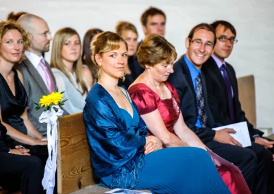 Gäste sitzen in der Friedenskirche Dachau bei einer Hochzeit. Hochzeitsfotografie nordlich von München.