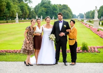 Brautpaar mit Freunden im Garten vom Schloss Nymphenburg, festgehalten bei einer Hochzeitsreportage in Muenchen.