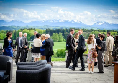 Hochzeitsgaeste im Freien bei einer Feier im Aschbacher Hof, Berge im Hintergrund, Kreis Rosenheim.