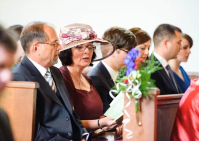 Gäste sitzen in einer Kirche bei einer Hochzeitszeremonie in Gauting nahe Muenchen. Hochzeitsfotografie Moment.
