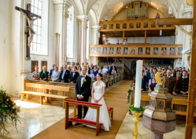 Brautpaar bei kirchlicher Trauung vor Gemeinde in St. Johann-Baptist Irschenberg, Hochzeitsfoto.