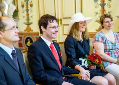 Brautpaar bei standesamtlicher Trauung in Schloss Ismaning, lächelnd und Hand haltend, Hochzeitsfotografien.