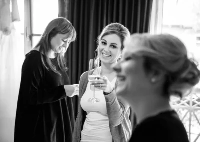 Drei Frauen beim Getting Ready mit Sektglas bei Hochzeit in Landshut, aufgenommen von Hochzeitsfotograf.