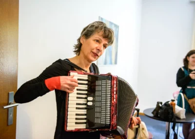 Frau spielt Akkordeon bei standesamtlicher Trauung in Muenchen-Schwabing, Bild der Hochzeitsfotografie.