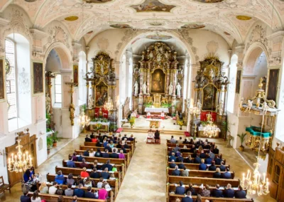 Kirchliche Trauung in Heilig-Geist-Kirche Neuburg, erfasst in einer Hochzeitsreportage mit Altar und Gaesten.