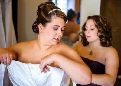 Braut richtet Kleid zurecht, Begleitung hilft beim Getting Ready, Hochzeitsfotografie nahe Donauwoerth.